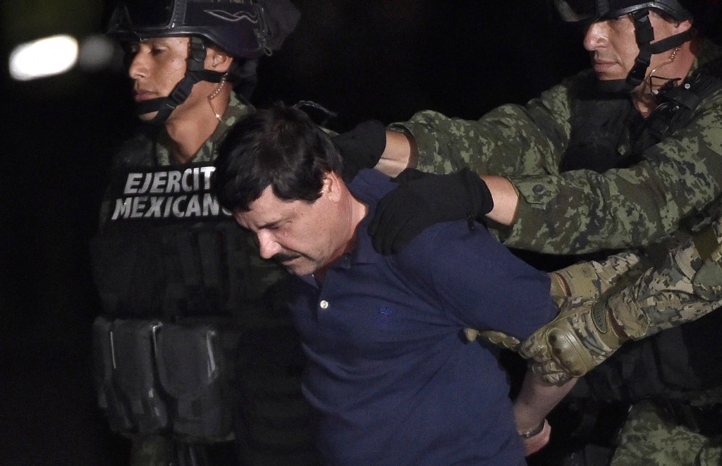 Drug kingpin Joaquin "El Chapo" Guzman is escorted into a helicopter at Mexico City's airport on January 8, 2016 following his recapture during an intense military operation in Los Mochis, in Sinaloa State. Mexican marines recaptured fugitive drug kingpin Joaquin "El Chapo" Guzman on Friday in the northwest of the country, six months after his spectacular prison break embarrassed authorities. AFP PHOTO / OMAR TORRES / AFP / OMAR TORRES (Photo credit should read OMAR TORRES/AFP/Getty Images)
