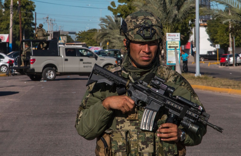 A marine stands guard on January 9, 2016 on the street in front of the house where five gang suspects were killed in the military operation which resulted in the recapture of Joaquin "El Chapo" Guzman in the city of Los Mochis, Sinaloa State, Mexico. Mexican marines recaptured fugitive drug kingpin Joaquin "El Chapo" Guzman on January 8 in the northwest of the country, six months after his spectacular prison break embarrassed authorities. AFP PHOTO / HECTOR GUERRERO / AFP / HECTOR GUERRERO (Photo credit should read HECTOR GUERRERO/AFP/Getty Images)