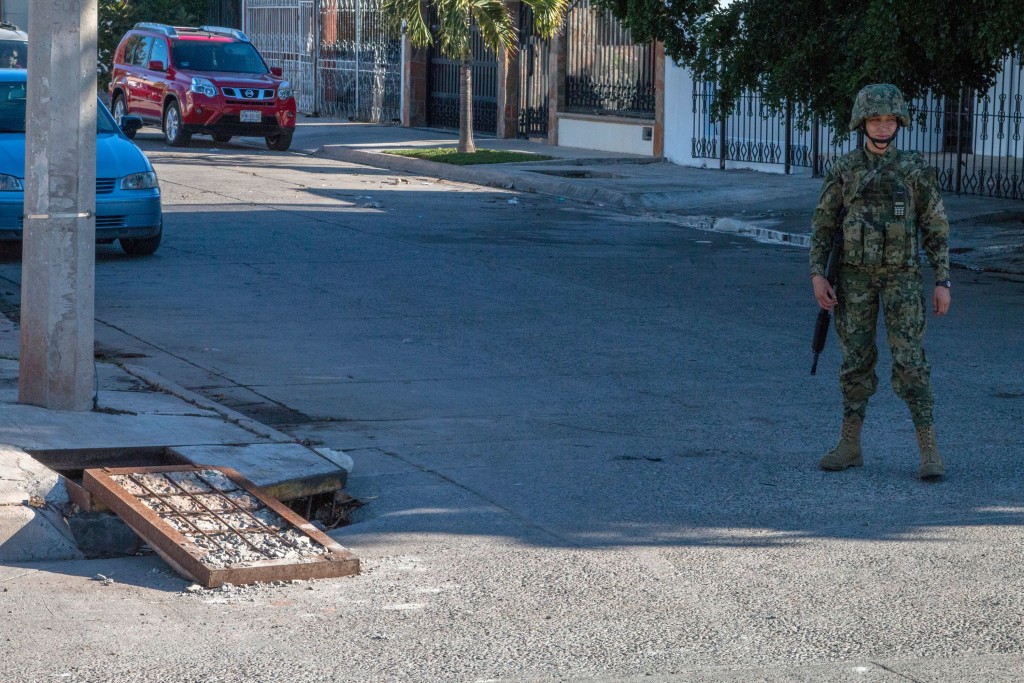A marine stands guard next to a manhole of the sewer system through which drug kingpin Joaquin "El Chapo" Guzman tried to escape during the military operation that resulted in his recapture in the city of Los Mochis, Sinaloa State, Mexico. Mexican marines recaptured fugitive drug kingpin Joaquin "El Chapo" Guzman on January 8 in the northwest of the country, six months after his spectacular prison break embarrassed authorities. AFP PHOTO / HECTOR GUERRERO / AFP / HECTOR GUERRERO (Photo credit should read HECTOR GUERRERO/AFP/Getty Images)